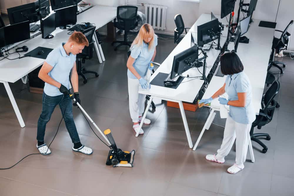 cleans-floor-group-workers-clean-modern-office-together-daytime
