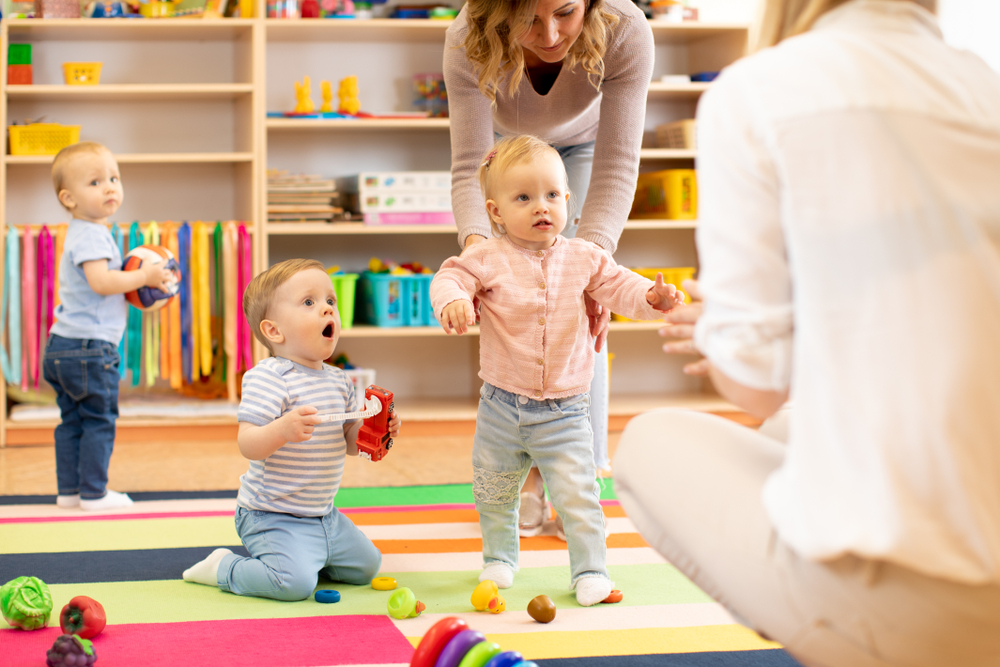 Group,Of,Workers,With,Babies,In,Nursery,Or,Kindergarten