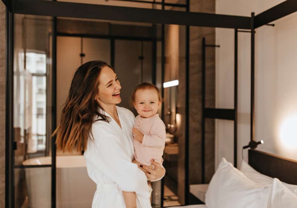 woman-bathrobe-holds-small-smiling-child-portrait-mother-with-daughter-bedroom